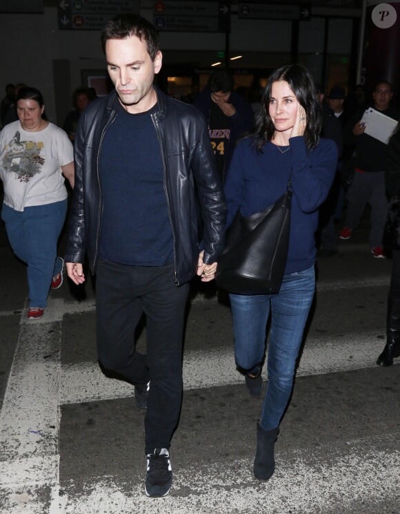 Courteney Cox et son fiancé Johnny McDaid à l'aéroport de Los Angeles, le 17 décembre 2014. Le couple semble heureux à leur retour d'un voyage romantique au cours duquel ils ont visité des caves au nord de la Californie.