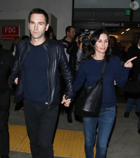 Courteney Cox et son fiancé Johnny McDaid à l'aéroport de Los Angeles, le 17 décembre 2014. Le couple semble heureux à leur retour d'un voyage romantique au cours duquel ils ont visité des caves au nord de la Californie.