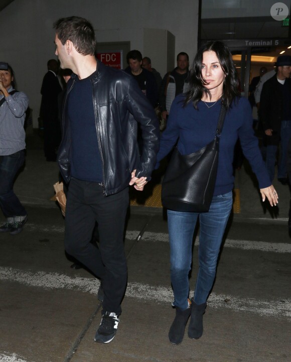 Courteney Cox et son fiancé Johnny McDaid à l'aéroport de Los Angeles, le 17 décembre 2014. Le couple semble heureux à leur retour d'un voyage romantique au cours duquel ils ont visité des caves au nord de la Californie.