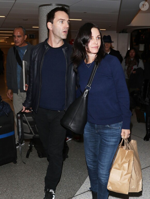 Courteney Cox et son fiancé Johnny McDaid à l'aéroport de Los Angeles, le 17 décembre 2014. Le couple semble heureux à leur retour d'un voyage romantique au cours duquel ils ont visité des caves au nord de la Californie.