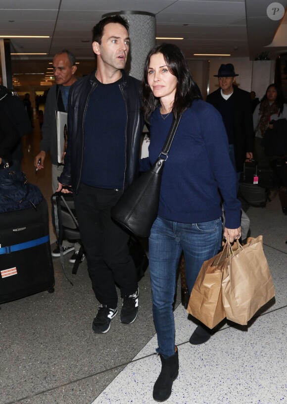 Courteney Cox et son fiancé Johnny McDaid à l'aéroport de Los Angeles, le 17 décembre 2014. Le couple semble heureux à leur retour d'un voyage romantique au cours duquel ils ont visité des caves au nord de la Californie.