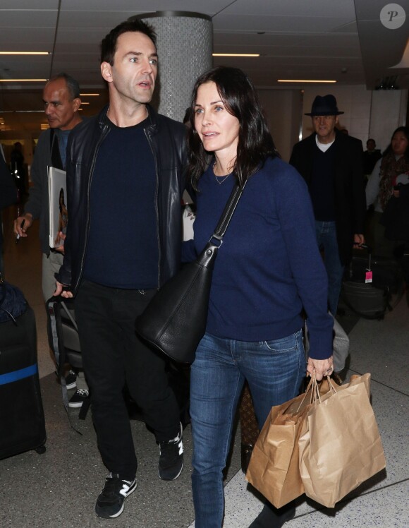 Courteney Cox et son fiancé Johnny McDaid à l'aéroport de Los Angeles, le 17 décembre 2014. Le couple semble heureux à leur retour d'un voyage romantique au cours duquel ils ont visité des caves au nord de la Californie.