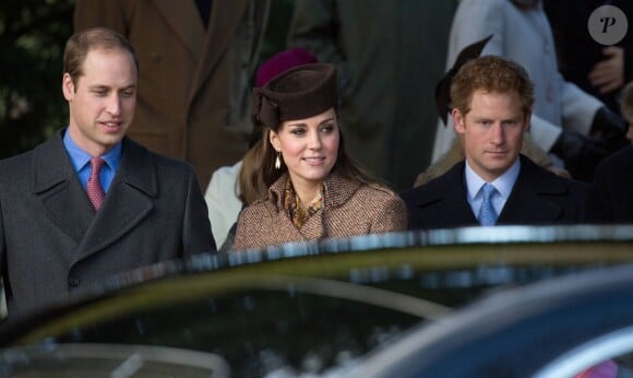 Kate Middleton, duchesse de Cambridge, entre les princes William et Harry, le 25 décembre 2014 lors du rassemblement de la famille royale pour la messe de Noël à Sandringham.