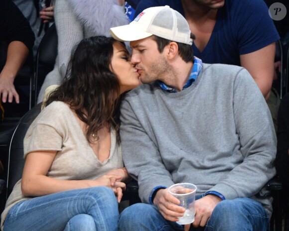Mila Kunis et son fiancé Ashton Kutcher très amoureux et très complices au match de basket des Lakers à Los Angeles, le 19 décembre 2014. Les rumeurs concernant un mariage secret vont bon train.