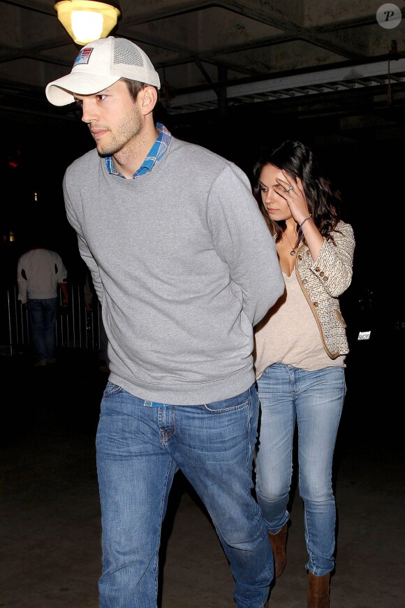Ashton Kutcher et Mila Kunis quittant le Staples Center le 19 décembre 2014.