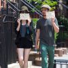 Emma Stone et son petit-ami Andrew Garfield se cachent le visage avec chacun un message en sortant d'un déjeuner au Cafe Cluny à New York, le 17 juin 2014. Sur leurs papiers on peut lire qu'ils n'ont pas besoin de publicité mais que les associations mentionnées en ont vraiment besoin. 