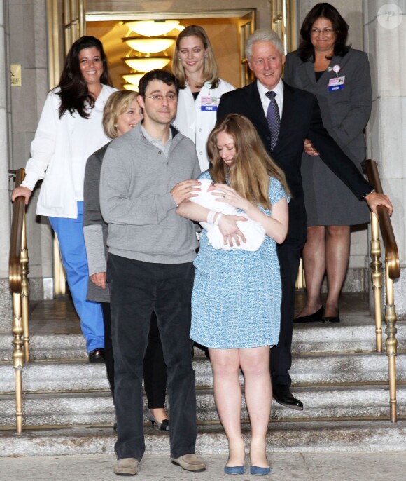 Chelsea Clinton Mezvinsky, son mari Marc Mezvinsky et leur fille Charlotte posent avec Bill et Hillary Clinton à leur sortie de l'hôpital à New York, le 29 septembre 2014.