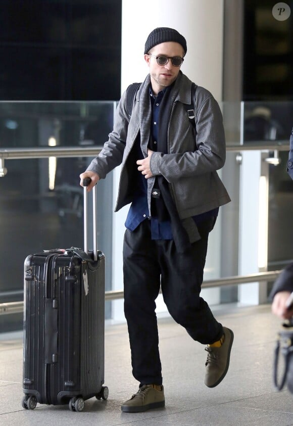 Robert Pattinson arrive à l'aéroport de Londres, le 25 février 2014.