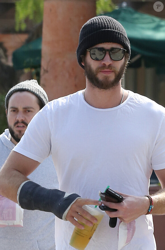 Exclusif - Liam Hemsworth qui porte un plâtre, se rend chez Starbucks avec un ami à Malibu le 17 février 2015.