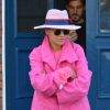 Rita Ora quitte son domicile à Londres, chapeau rose Maison Michel sur la tête et baskets Rita Ora for adidas Originals (modèle Superstar 80s, collection Super Pack) aux pieds. Le 18 mars 2015.