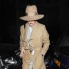 Rita Ora, de sortie à Londres, porte un chapeau et un manteau beiges, une chemise et un jean Off-White, un sac Yves Saint Laurent, un sautoir Chanel et des souliers Christian Louboutin. Le 12 mars 2015.