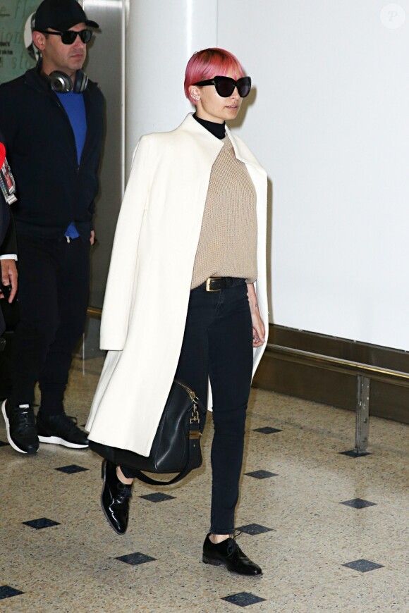 Nicole Richie, cheveux roses et lunettes de soleil House of Harlow 1960 sur le nez, arrive à l'aéroport de Sydney. Elle porte également un jean Ksubi et un sac Givenchy (modèle Antigona). Le 18 mars 2015.