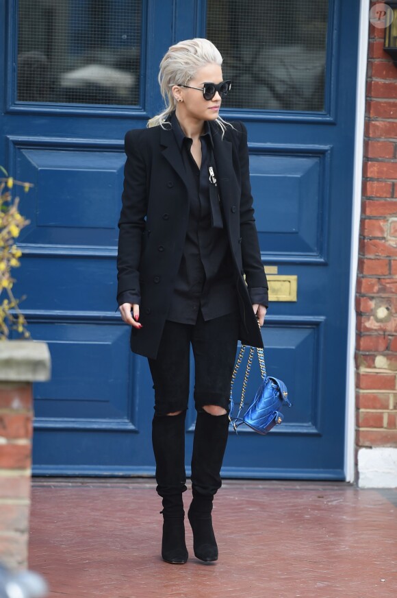 Rita Ora, tout de noir vêtue et portant un sac à dos matelassé Chanel, quitte son domicile à Londres, le 26 mars 2015.