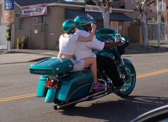 Exclusif - Miley Cyrus monte derrière un inconnu sur sa moto Harley Davidson pour profiter d'une escapade colorée avec un casque assorti avant de continuer la route avec ses amis dans leur Porsche décapotable à Hollywood, le 12 avril 2015.