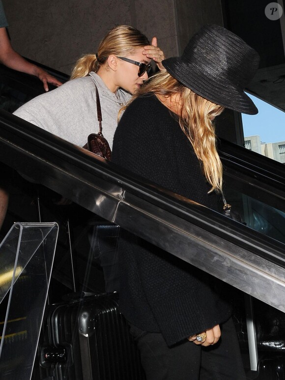 Mary-Kate Olsen et Ashley Olsen vont prendre un avion à l'aéroport de LAX à Los Angeles, le 1er août 2014.