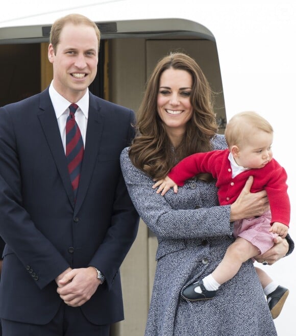 Le prince William, Catherine Kate Middleton la duchesse de Cambridge et leur fils George montent à bord d'un avion pour rentrer à Londres après leur visite officielle en Australie, le 25 avril 2014.