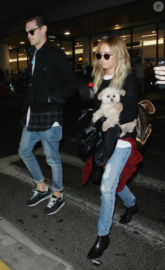Ashley Tisdale et son mari Christopher French à l'aéroport de Los Angeles avec leur chien le 16 juin 2015.  