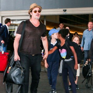 Brad Pitt avec sa fille Zahara, ses enfants Shiloh et Knox derrière lui, arrivant en famille à l'aéroport de Los Angeles le 5 juillet 2015