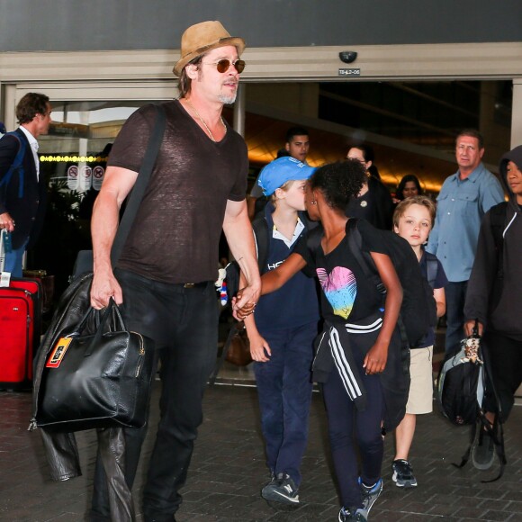 Brad Pitt avec sa fille Zahara, ses enfants Shiloh et Knox derrière lui, arrivant en famille à l'aéroport de Los Angeles le 5 juillet 2015