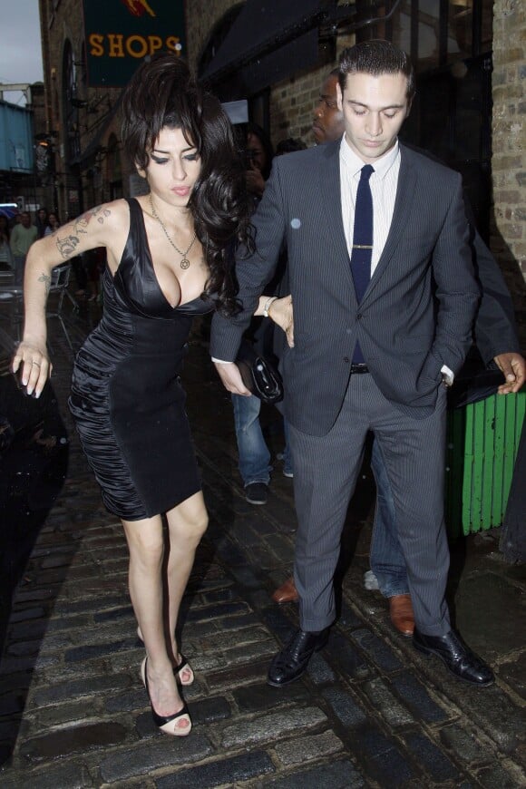 Amy Winehouse et Reg Traviss à la sortie du restaurant Shaka Zulu à Londres, le 4 août 2010