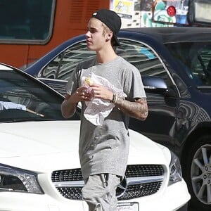 Exclusif - Justin Bieber mange un sandwich alors qu'il retourne au Montage Beverly Hills Hotel à Beverly Hills, le 15 août 2015. Le chanteur a refusé de signer des autographes et de faire des photos avec ses fans car il ne voulait pas être dérangé pendant qu'il mangeait.  Exclusive - For Germany Call For Price - Justin Bieber is seen eating a sandwich as he makes his way back to the Montage Beverly Hills Hotel in Beverly Hills, California on August 15, 2015. Justin refused some fans an autograph and a picture because he was enjoying his sandwich and didn't want to be bothered.15/08/2015 - Beverly Hills