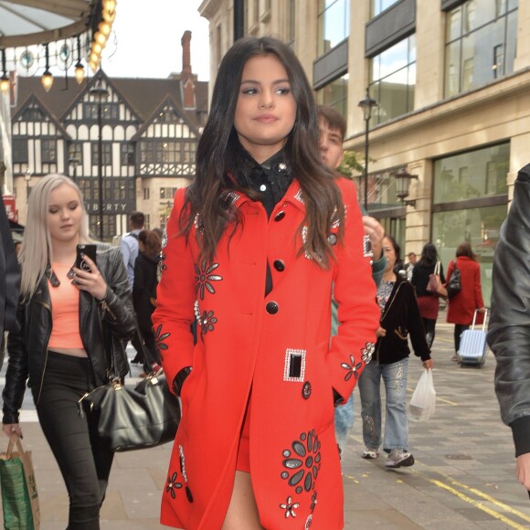 Selena Gomez en pleine promotion à Londres, le 25 septembre 2015. Elle porte 2 tenues : une robe noire et une tenue rouge.