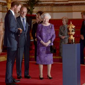 Le prince Harry, le prince Philip et la reine Elizabeth II posent devant la coupe Webb Ellis - Réception au palais de Buckingham avec les plus grands joueurs de rugby de la Coupe du Monde et d'autres protagonistes de la compétition, à Londres, le 12 octobre 2015