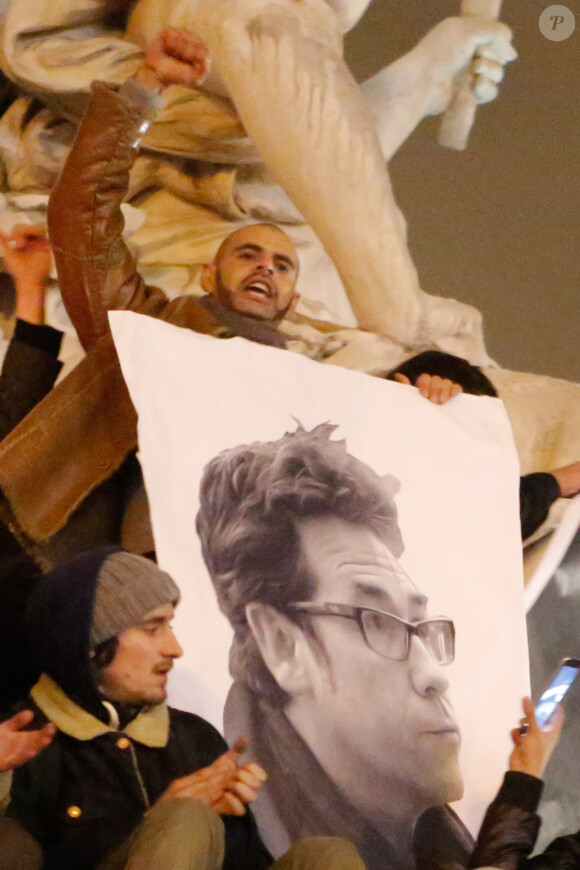 Une photo de Tignous brandie lors d'un rassemblement sur la place de la République suite à l'attentat au siège de Charlie Hebdo à Paris le 7 janvier 2015.