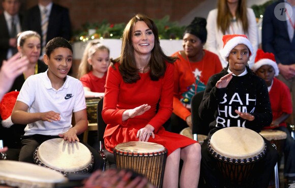 Kate Middleton, duchesse de Cambridge, vêtue d'une robe Alexander McQueen, a participé le 15 décembre 2015 à la fête de Noël de l'école du Anna Freud Centre, un établissement du nord de Londres qui prend en charge les enfants présentant des troubles du comportement et soutient leurs familles. Elle a notamment pris part à un atelier collage et un cours de percussions !