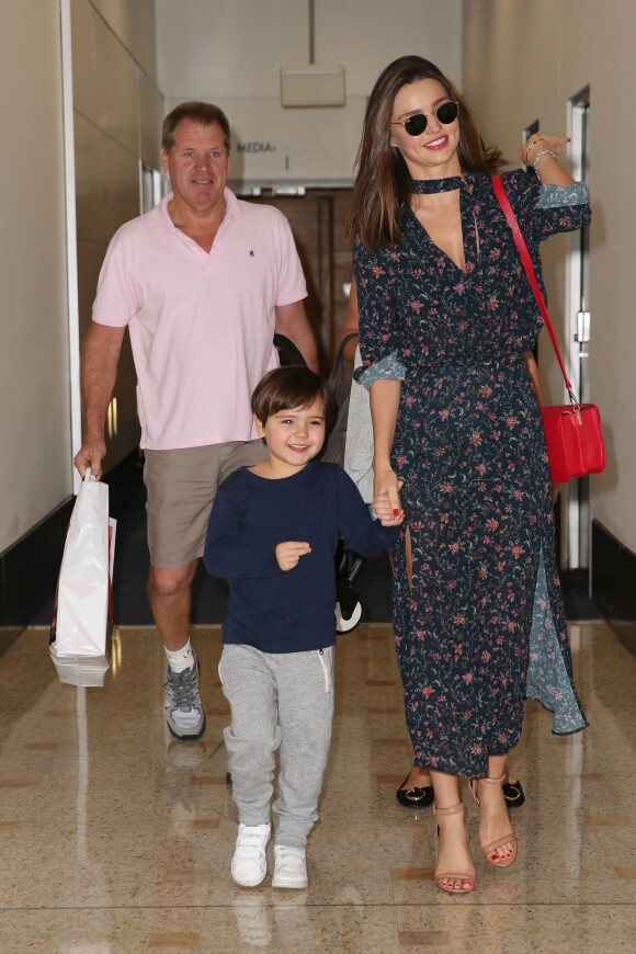 Miranda Kerr, habillée d'une robe à motifs floraux Zimmermann, chaussée de sandales Alexander Wang et tenant un sac Samantha Thavasa, arrive à Sydney avec son fils Flynn et ses parents. Le 15 décembre 2015.