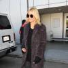 Heidi Klum à l'aéroport LAX à Los Angeles, porte des lunettes de soleil The Row, un manteau en fausse fourrure Elizabeth and James, un pull et un jean noirs, des bottines Saint Laurent. Le 12 décembre 2015.
