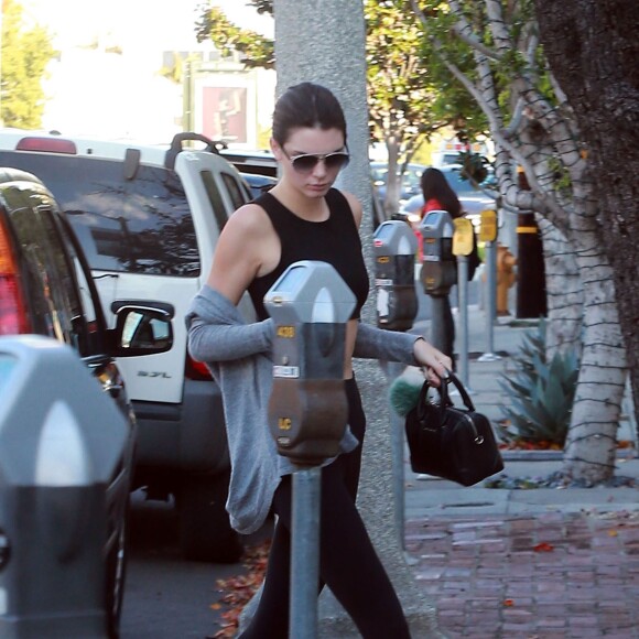 Kendall Jenner met de l'argent dans un parcmètre à West Hollywood, le 8 janvier 2016. Elle se cache des photographes avec son sac Givenchy!