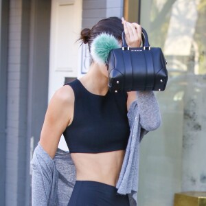 Kendall Jenner met de l'argent dans un parcmètre à West Hollywood, le 8 janvier 2016. Elle se cache des photographes avec son sac Givenchy!