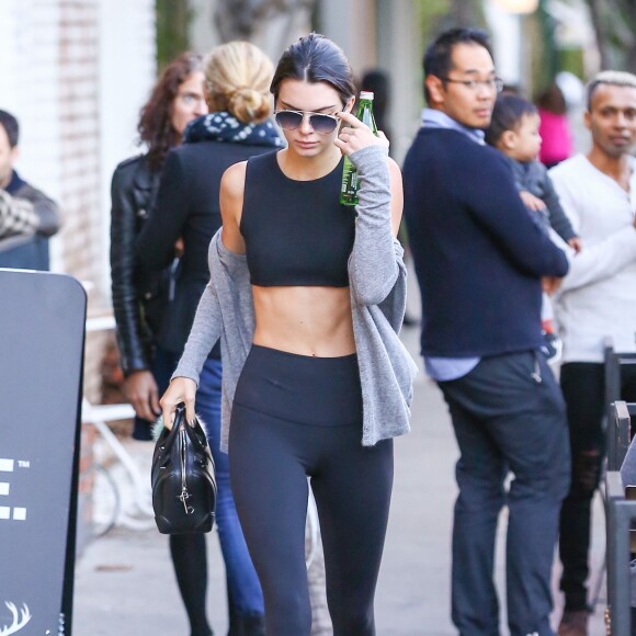 Kendall Jenner met de l'argent dans un parcmètre à West Hollywood, le 8 janvier 2016. Elle se cache des photographes avec son sac Givenchy!