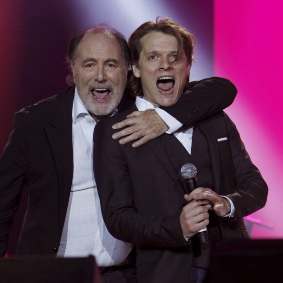 Michel Delpech et le chanteur Bénabar sur scène, lors du concert "Touche pas à mon pote", organisé par l'association SOS Racisme au Champ de Mars, à Paris, le 14 juillet 2011.