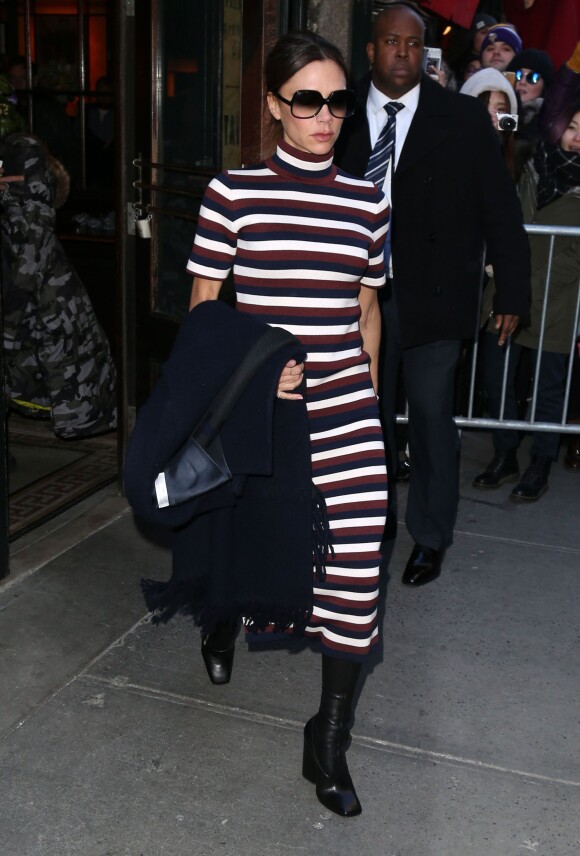 Victoria Beckham quitte le restaurant Balthazar à New York, habillée d'un manteau, d'un pull à col roulé et d'une jupe rayés Victoria Beckham (collection automne-hiver 2016-2017). Le 14 février 2016.