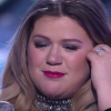 Kelly Clarkson enceinte et émue aux larmes interprète son titre Piece by Piece qui parle de l'abandon de son père, sur le plateau de l'émission American Idol. Une prestation émouvante qui a fait pleurer Keith Urban et bouleversée Jennifer Lopez. Image extraite d'une vidéo publiée sur Youtube, le 25 février 2016.
