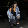 Kim Kardashian surprise à l'aéroport LAX à Los Angeles, porte une veste en denim custom Himumimdead, un body noir The Line by K, un jean J Brand, un sac Hermès (modèle Birkin) et des bottines en plexiglas YEEZY (collection Season 3). Le 11 avril 2016.
