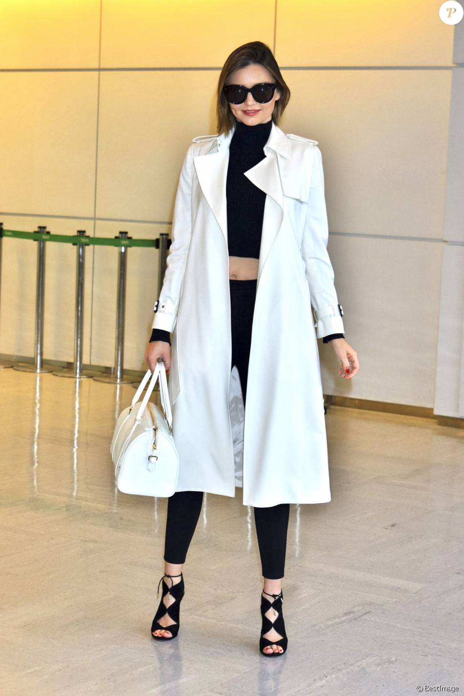 Miranda Kerr arrive à l&#039;aéroport Narita à Tokyo, habillée d&#039;un trench-coat ivoire Barneys New York, d&#039;un pull court à col roulé et d&#039;un jean noirs, et de chaussures Aquazurra (modèle Pasadena). Le 12 avril 2016.