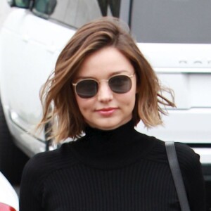 Miranda Kerr surprise à Malibu, porte un pull court à col roulé, un jean Mother, un sac Céline et des baskets Alaïa. Le 7 avril 2016.