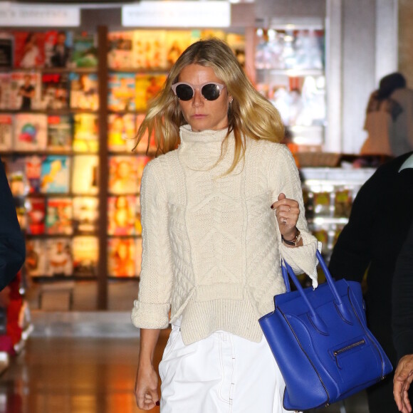 Gwyneth Paltrow arrive à l'aéroport de JFK à New York, habillée d'un pull Céline, d'un pantalon Dries van Noten et de baskets adidas x Raf Simons (modèle Stan Smith). Des lunettes de soleil Self Portrait x Le Specs et un sac Céline accessoirisent sa tenue. Le 11 avril 2016.