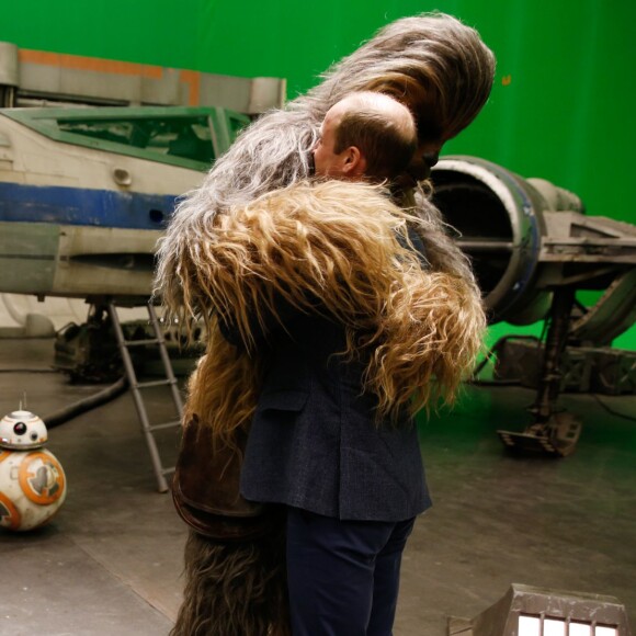 Le prince William fait un câlin à Chewbacca sous l'oeil amusé de l'acteur John Boyega lors de sa visite des coulisses du tournage de Star Wars des studios Pinewood le 19 avril 2016.