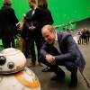 Le prince William regarde de près le droïde BB-8 lors de sa visite des coulisses du tournage de Star Wars des studios Pinewood le 19 avril 2016.