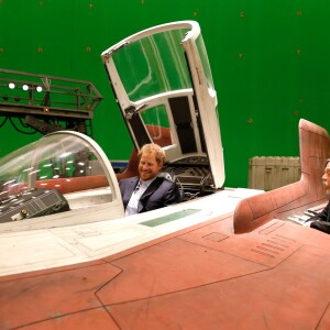 Le prince Harry se place aux commandes d'un A-Wing Fighter sous l'oeil amusé de l'acteur Mark Hamill lors de sa visite des coulisses du tournage de Star Wars des studios Pinewood le 19 avril 2016.