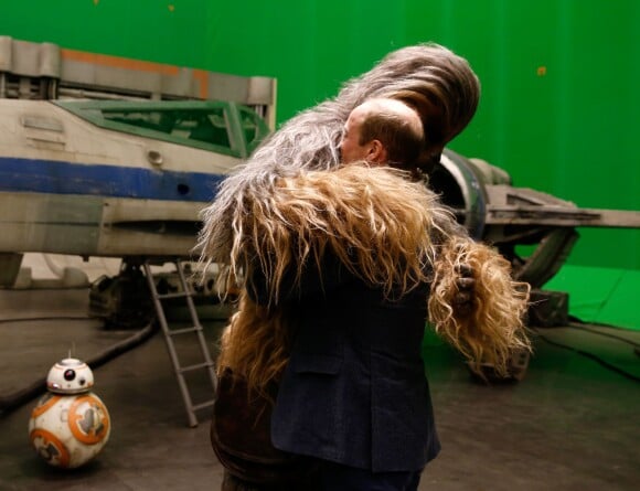 Le prince William fait un câlin à Chewbacca sous l'oeil amusé de l'acteur John Boyega lors de sa visite des coulisses du tournage de Star Wars des studios Pinewood le 19 avril 2016.