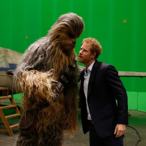 Le prince Harry rencontre Chewbacca lors de sa visite des coulisses du tournage de Star Wars des studios Pinewood le 19 avril 2016.