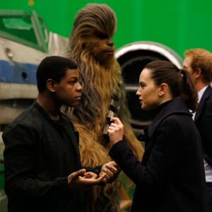 Les acteurs John Boyega et Daisy Ridley discutent pendant que le prince Harry rencontre Chewbacca lors de sa visite avec son frère dans les coulisses du tournage de Star Wars 8, dans les studios londoniens de Pinewood, à Iver Heath le 19 avril 2016.