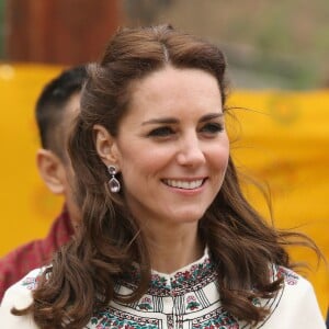 Kate Middleton s'exerçant au tir à l'arc sous l'oeil amusé du prince William à Thimphou, à l'occasion de leur voyage officiel au Bhoutan le 14 avril 2016