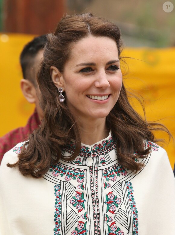 Kate Middleton s'exerçant au tir à l'arc sous l'oeil amusé du prince William à Thimphou, à l'occasion de leur voyage officiel au Bhoutan le 14 avril 2016
