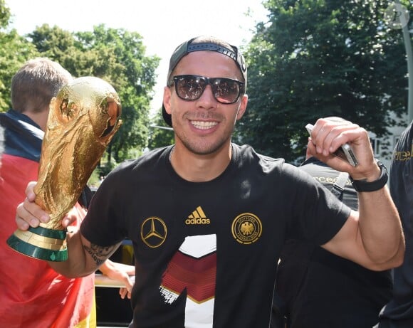 Lukas Podolski fête la victoire de l'Allemagne lors de la Coupe du monde 2014 à Berlin le 15 juillet 2014.